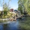 Fish Culturist II, Greg Carpenter, snaps a picture of the fish ladder and outdoor brood holding raceways while wading in Ship Creek.