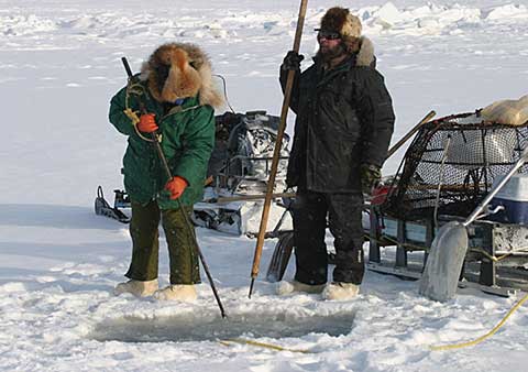 ALASKA: ICE FISHING. An Eskimo man ice fishing in Nome