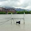 Cables from the submerged sonar transducer carry sonar data to a computer in a shelter just above the bank. In this photo taken from the right bank, the Million Dollar Bridge—upstream of the sonar site—is pictured to the upper left.